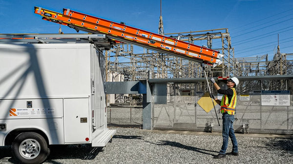 worker unloading drop down ladder racks