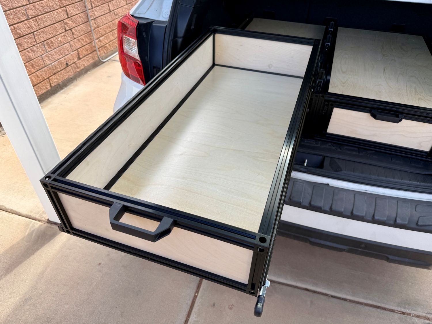 Open top sliding basket mounted above a TNT Auto Drawer