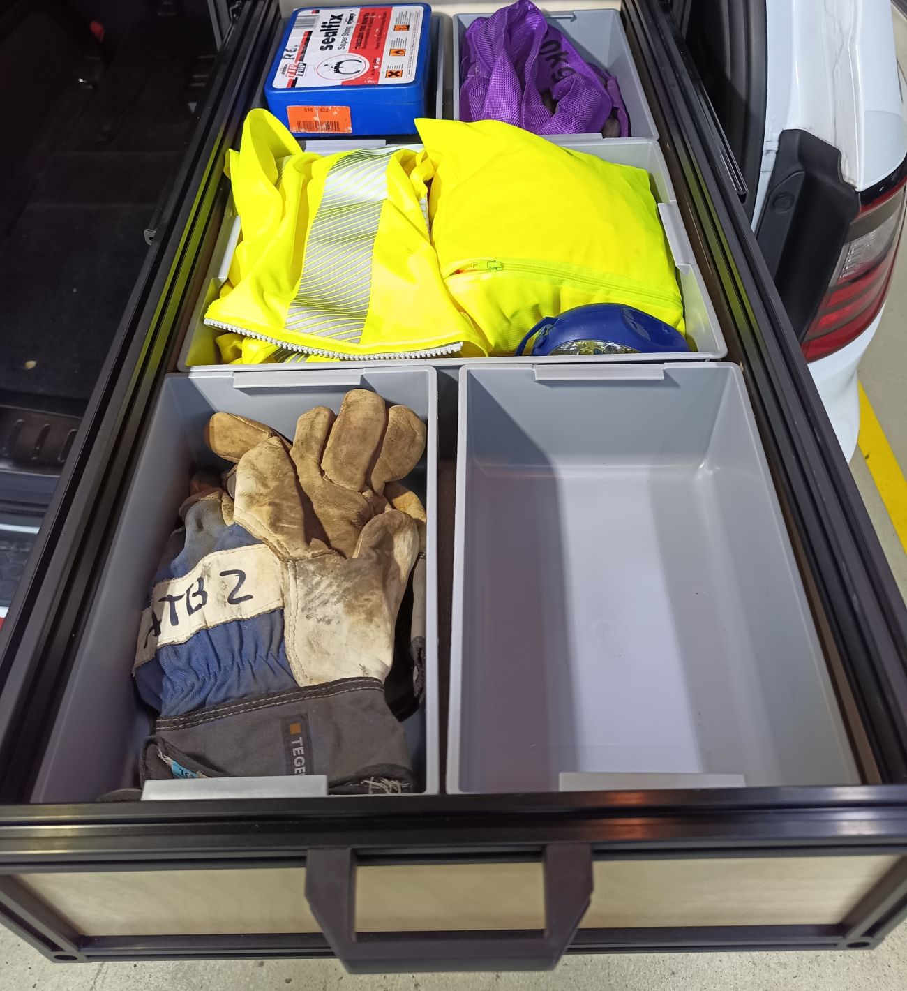Safety gear organized inside an SUV cargo drawer