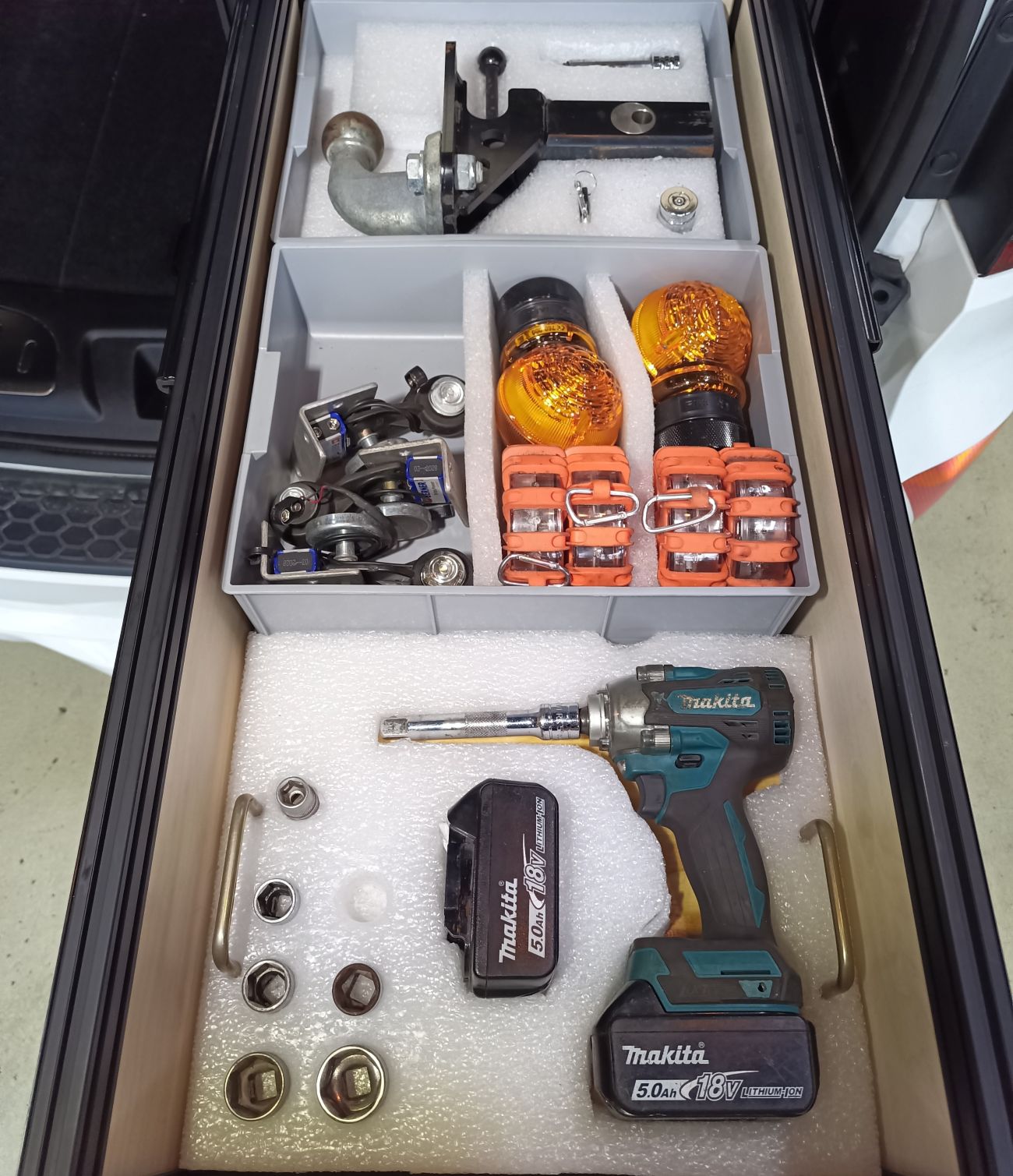Tools and equipment organized inside an SUV cargo drawer